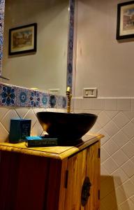 ローマにあるMoroni Trastevere Cozy Apartmentのバスルーム(カウンターに黒い洗面台付)