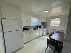 Falls House Downtown Niagara Falls Canada في شلالات نياجارا: مطبخ مع طاولة وثلاجة بيضاء +11 صورة