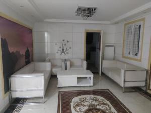 a living room with white furniture and a chandelier at Chambre privée à Bobigny -salle de bain et toilettes sont commune, -pas de cuisine in Bobigny
