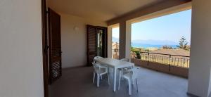 una mesa blanca y sillas en un balcón con vistas en Casa vacanza Luisa, en Alcamo Marina