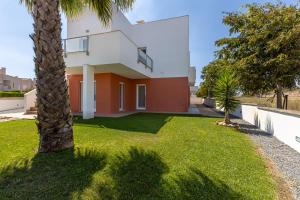 una palmera delante de una casa en Casa Kiko, en Burgau