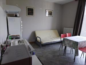 カントゥにあるSoggiorno Manuのソファ、テーブル、冷蔵庫が備わる小さな客室です。