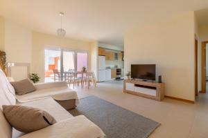 Una sala de estar con un sofá y un televisor de pantalla plana. en Casa Kiko, en Burgau