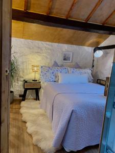 1 dormitorio con 1 cama con colcha blanca en Old Nursery, en Coity
