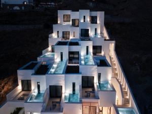 un edificio con una fachada iluminada por la noche en CUBIC Mykonos Seafront Design Suites en Ornos