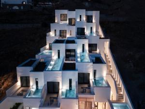 a building with a lit up facade at night at CUBIC Mykonos Seafront Design Suites in Ornos