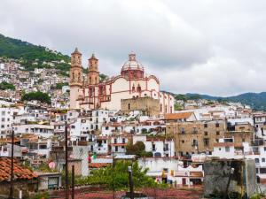 vistas a una ciudad con una iglesia en una colina en María Bonita by Rotamundos en Taxco de Alarcón