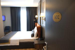 a hotel room with a bed and a sign on the wall at The Pearl Airport Hotel in Arnavutköy