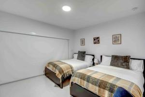 - 2 lits dans une chambre aux murs blancs dans l'établissement Stylish Retreat Heated Pool Basketball Game Room L41, à Cutler Bay