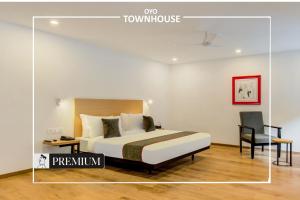 a hotel room with a bed and a chair at Townhouse 165 Netaji Road in Ahmedabad