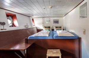 Kleines Zimmer mit 2 Betten und einem Tisch in der Unterkunft Schiffsherberge Pöppelmann in Dresden