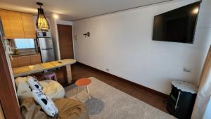 un salon avec une table et une télévision sur un mur dans l'établissement San Diego, à Santiago