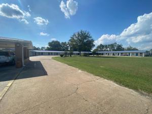 a large building with a grass field in front of it at Budget inn in Alma
