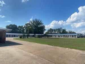 a large building with a grass field in front of it at Budget inn in Alma