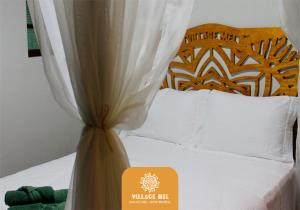 蜂蜜島的住宿－Pousada Village Mel，酒店客房,配有一张带标志的床