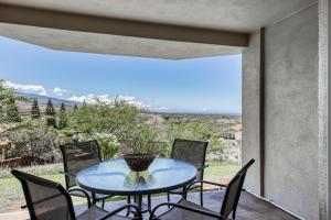 a table and chairs on a balcony with a view at Greens At Waikoloa L101 in Waikoloa Village