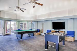 a living room with a pool table and a flat screen tv at Greens At Waikoloa L101 in Waikoloa Village