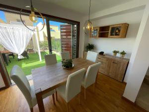 une salle à manger avec une table en bois et des chaises blanches dans l'établissement Tenerife Family Home, à Santa Úrsula