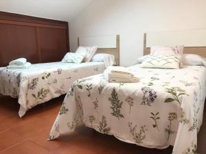 1 dormitorio con 2 camas con edredones blancos en Ático La Canal, en Santa Cruz de Bezana