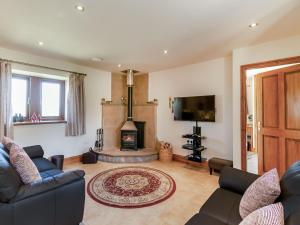 a living room with a couch and a fireplace at Routster Cottage in Giggleswick