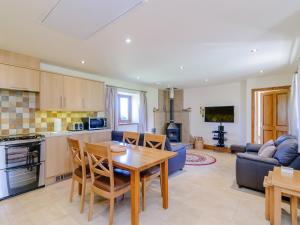 a kitchen and living room with a table and chairs at Routster Cottage in Giggleswick