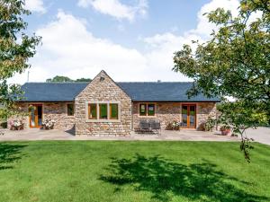 a stone house with a large yard at Routster Cottage in Giggleswick