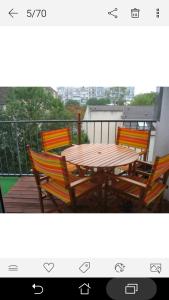 Grande chambre double chez l'habitant في لونغجومياو: طاولة وكراسي خشبية على شرفة