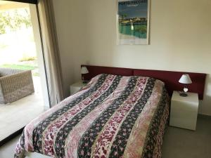 ein Schlafzimmer mit einem Bett mit einer bunten Decke darauf in der Unterkunft A SUARA- CORSE- APPARTEMENT 2 chambres 5 à 7 pers, jardin et piscine in Porto-Vecchio