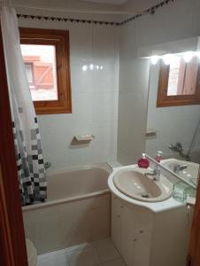 y baño con lavamanos, bañera y lavamanos. en Apartamento con terraza y vistas panorámicas en Taüll, en Taüll