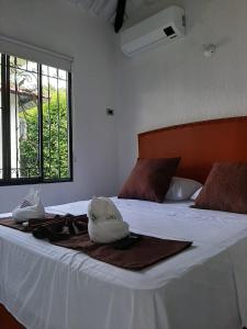 Schlafzimmer mit einem Bett mit weißer Bettwäsche und einem Fenster in der Unterkunft Cabañas LLano Lindo Apiay in Villavicencio