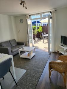 uma sala de estar com um sofá e uma mesa em FlipFlop em Noordwijk aan Zee