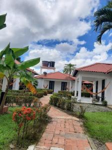 una casa con una pasarela de ladrillo delante de ella en Cabañas LLano Lindo Apiay en Villavicencio