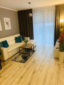 a living room with a white couch and a table at Apartament Champion in Gorzów Wielkopolski
