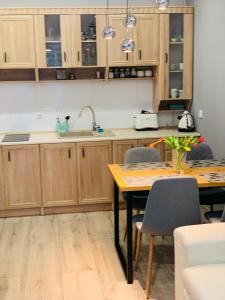 a kitchen with wooden cabinets and a table with chairs at Apartament Champion in Gorzów Wielkopolski