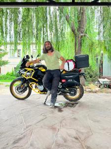 un hombre está sentado en una moto en Assem Hostel Dostyk, en Almaty
