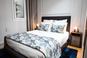 a bedroom with a bed with blue and white sheets and pillows at 6/4 de Lamego in Lamego