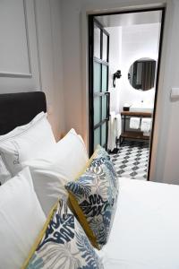 a bedroom with a white bed and a mirror at 6/4 de Lamego in Lamego