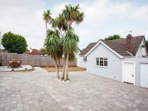 eine Palme vor einer weißen Garage in der Unterkunft HONEYBROOK - Cosey detached home, modern, spacious in Torquay