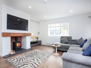 a living room with a couch and a fireplace at HONEYBROOK - Cosey detached home, modern, spacious in Torquay