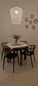 - une table avec deux chaises et un vase de fleurs dans l'établissement Casa Pellegrino, à Polignano a Mare