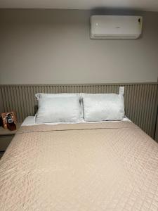 een bed met een witte deken en airconditioning bij Altamare - Pé na areia in João Pessoa
