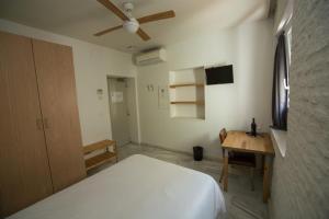 a bedroom with a white bed and a desk at The Nomad Hostel&Pension in Seville
