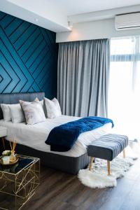 1 dormitorio con 1 cama grande y pared azul en 703 Menlyn Maine Residences, The Trilogy, en Pretoria