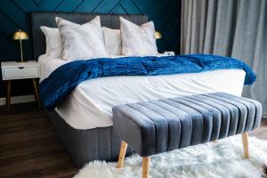 a bed with blue and white pillows and a blue blanket at 703 Menlyn Maine Residences, The Trilogy in Pretoria