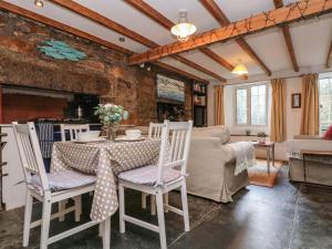 een woonkamer met een tafel en stoelen bij Tinners Cottage in Saint Cleer