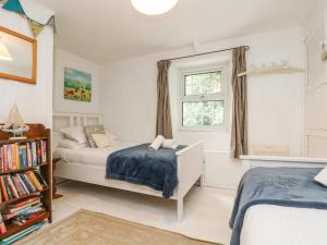1 dormitorio con 2 camas y ventana en Tinners Cottage, en Saint Cleer