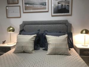 a bedroom with a bed with pillows and two lamps at El Patio de Rivero con garaje, Avilés in Avilés