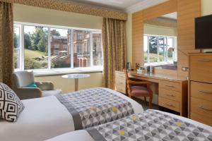 um quarto de hotel com uma cama e uma secretária em The Welcombe Golf & Spa Hotel em Stratford-upon-Avon