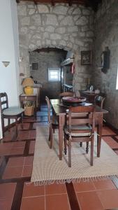 comedor con mesa, sillas y pared de piedra en Quintinha dos Amores, en Vila Verde