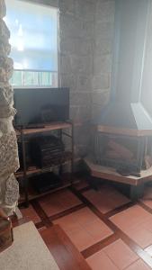 sala de estar con TV y chimenea en Quintinha dos Amores, en Vila Verde